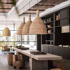 an indoor dining area with wicker lamps and chairs