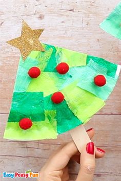 someone is making a paper christmas tree craft with popsicle sticks and colored construction paper