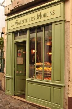 a green store front with donuts in the window