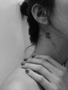 black and white photograph of woman's neck with the word love tattooed on it