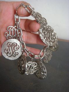 Decadencefashion Vintage Jewelry 1970s Monogram Charm Bracelet Silver Metal Chunky Heavy Charms packaged with white jewelry box Measurements Length - 7" Charms range in size 3/4" to 1 1/8" to 1 1/4" Materials - Silver Metal Condition - Excellent True Vintage *wear a little bit of history* XOXOXOXOXOXOXOXOXOXOXOXOXOXO Instagram: decadence@decadencefashion Decadencefashion: Curated by searching out and carefully selecting fabulous vintage items in excellent condition. Specializing in vintage fashion from the 1970s, 1980s, 1990s, 2000s *Reminder Note Please keep in mind, all of my items are 100% authentic vintage. This means they are not new and may show natural signs of wear and age. I do my very best to make note of any and all flaws in the item description but there may be something tiny t Elegant Metal Charm Bracelet With Engraving, Elegant Engraved Metal Charm Bracelet, Personalized Vintage Metal Jewelry, Vintage Silver Charm Bracelet For Formal Occasions, Vintage Silver Charm Bracelet For Wedding, Retro Metal Jewelry For Anniversary, Monogram Metal Jewelry For Gifts, Engraved Metal Jewelry For Party, Engraved Metal Jewelry For Parties