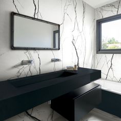 a black and white bathroom with marble walls