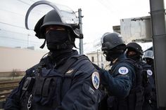 several police officers wearing face masks and helmets