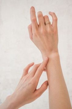 two hands reaching up towards each other with one hand holding the other's wrist