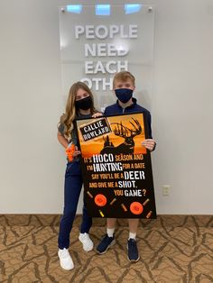 two children wearing face masks holding up a sign