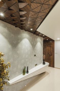 a large white bathtub sitting under a wooden ceiling next to a plant in a vase