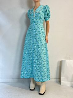 "- Vintage handmade blue floral peasant dress - Zipper and ties at the back - Feels like a thick polyester - No tags - Small  Bust: 19\" Waist: 15.5\" Length: 53\"" Blue Floral Print Dress With Square Neck, Blue Ditsy Floral Print Short Sleeve Maxi Dress, Blue Floral Short Sleeve Dress For Daywear, Blue Fitted Floral Dress With Square Neck, Blue Floral Dress With Square Neck And Fitted Style, Fitted Blue Floral Dress With Square Neck, Casual Blue Floral Dress With Square Neck, Blue Fitted Square Neck Floral Dress, Blue Ditsy Floral Print Maxi Dress For Garden Party