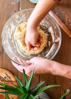 two hands reaching for dough in a bowl