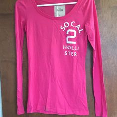 Bright Pink Long Sleeved T-Shirt From Hollister. Great Condition, Never Worn. Perfect For Evenings At The Beach! Pink Long Sleeve T-shirt With Text Print, Basic Pink T-shirt For Fall, Stretch Tops With Text Print For Spring, Spring Stretch Tops With Logo Print, Spring Stretch Top With Screen Print, Pink Long Sleeve T-shirt With Text, Summer Long Sleeve Shirt With Logo Print, Basic Pink Top With Screen Print, Basic Pink Tops With Screen Print