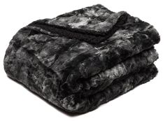 two black and white blankets stacked on top of each other in front of a white background