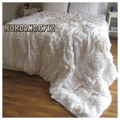 a white bed with ruffled bedspread and pillows