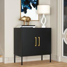 a black and gold sideboard with a lamp on top next to it in a living room