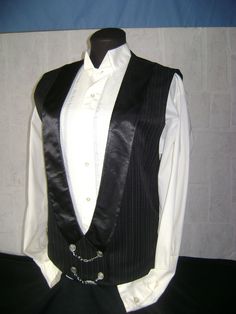 "A black with grey pin stripe power vest featuring a black satin lapel and silver buttons with silver chain accents.  The back of the vest is made from the same fabric with elastic at the waist for great fit.  This is a size 42 vest measuring 23\" from neck to hem in back with 17\" shoulders.  Fully lined with black satin, this is dry clean only.  This vest may be duplicated in custom size with limited availability of the fabric.  Pin stripes are considered a Power fabric and is a very elegant look.  Designed to be used for Victorian or Steampunk, but perfectly suitable for any formal occasion." Purple Waistcoat, Corset Vest, Steampunk Corset, Victorian Goth, Gothic Steampunk, Pin Stripe, Silver Buttons, Vest Dress, Black Satin