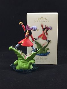 the figurines are posed next to each other in front of a card holder