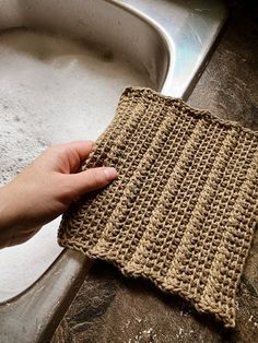 a hand holding a cloth over a sink