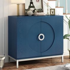 a blue cabinet sitting in the middle of a living room next to a stair case