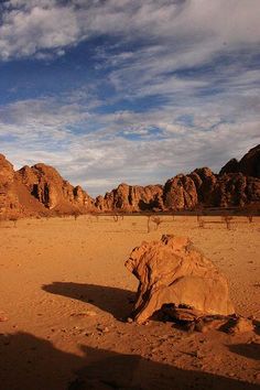 a large rock sitting in the middle of a desert