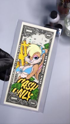 a person holding up a money card with an image of cartoon character on the front