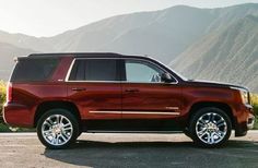 a red suv parked in front of mountains