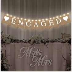 a sign that says engaged and mr and mrs on top of a table with flowers