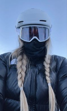 a woman wearing ski goggles and a black jacket