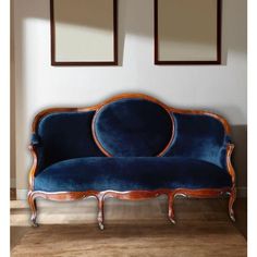 a blue couch sitting in front of two mirrors