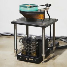 an old record player is sitting on top of a stand with its turntable turned upside down