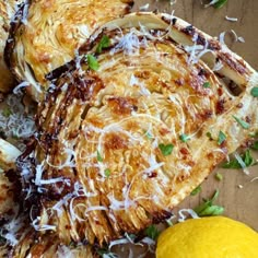 some food is laying out on a wooden table with lemons and parmesan cheese