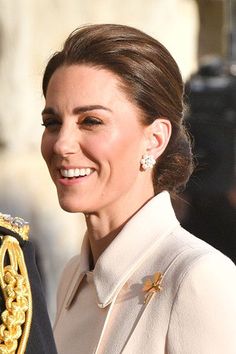 the duke and princess of cambridge smile as they stand next to each other