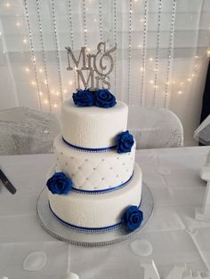 a three tiered wedding cake with blue roses