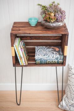 a wooden table with books and a vase on top