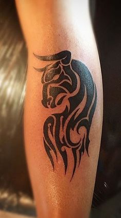 a black and white tattoo on the leg of a person's arm with a horse