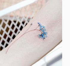 a small blue flower tattoo on the leg