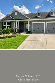 a gray house with white trim and two garages