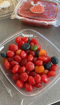 a plastic container filled with fruit sitting on top of a counter next to other containers