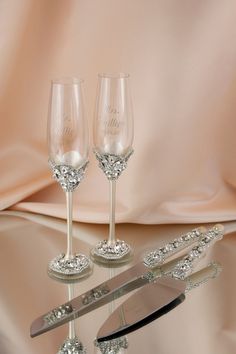 three crystal wine glasses on a table with a knife and other items in the foreground