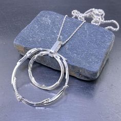 Argentium Silver Pendant - freeform circle LARGE double - sterling silver chain - Canadian handmade necklace - gift wife daughter girlfriend This pendant is Argentium silver wire, wrapped and fused into hollow Boulders shape.  After shaping the wire into small and medium irregular Boulder shapes, I then fuse them into permanent forms.   I melt the silver wire with my torch, until just at the melting point, adding more wire as the design forms.  After I am happy with the little Boulder shapes,  I Modern Round Wire Wrapped Jewelry, Modern Wire Wrapped Round Jewelry, Freeform Sterling Silver Necklace In Silver, Silver Freeform Sterling Silver Necklace, Minimalist Freeform Sterling Silver Jewelry, Modern Silver Wire Wrapped Necklace, Silver Freeform Wire Wrapped Jewelry, Modern Twist Silver Wire Wrapped Jewelry, Unique Silver Circular Necklace