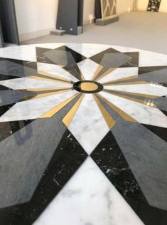 a black and white marble floor with gold trimmings in an art deco style