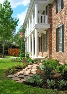 a brick house with white columns and black shutters