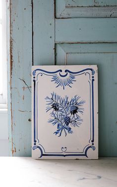 a blue and white tile with flowers on it