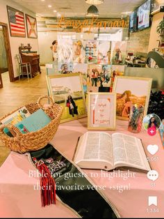 an open book sitting on top of a table next to two pictures and a basket