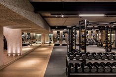 a gym with rows of dumbs and racks of exercise equipment in the middle of the room