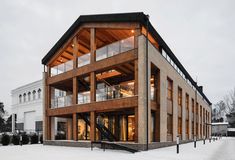 a large building with lots of windows in the middle of it's snow covered ground