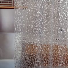 a bathroom with a shower curtain that has white and brown circles on it, next to a toilet