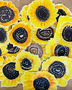 several sunflowers are arranged in the shape of circles on a wooden table top