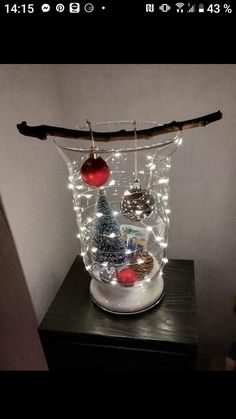 a glass jar filled with ornaments on top of a wooden table next to a wall