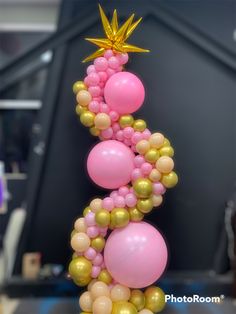 the balloon column is decorated with pink, gold and white balloons that are shaped like a star