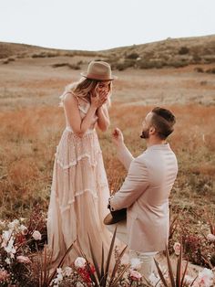 a man kneeling down next to a woman who is touching her face with both hands