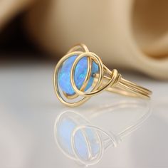 There is nothing ordinary about this wrap ring. set with a beautiful Blue Opal that goes well with any outfit. ☆ WHY THIS PIECE OF J E W E L R Y IS AWESOME! ☆ * Hand finished and made from high quality raw materials * Long lasting beauty & Timeless design * Set with a Blue Opal 8 mm ♡ WRAPPING ♡ * All 23 Summers jewels arrive in a cute pouch or gift box so they are gift ready. DELIVERY ✉ * Most items are ready made but some are made to order, Times for each items are shown on * Well packaged Ring Wire Wrapping, Unique Opal Ring, Cute Pouch, Unique Opal, Ring Wire, Wire Wrapped Ring, Wire Jewelry Designs, Ring Opal, Wrap Ring