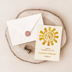 an envelope and wax stamp sitting on top of a piece of wood